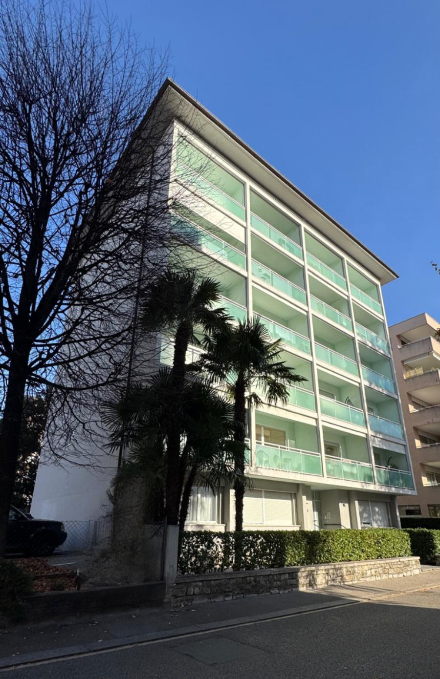 Full facade of Via del Tiglio 17 with palm trees in front