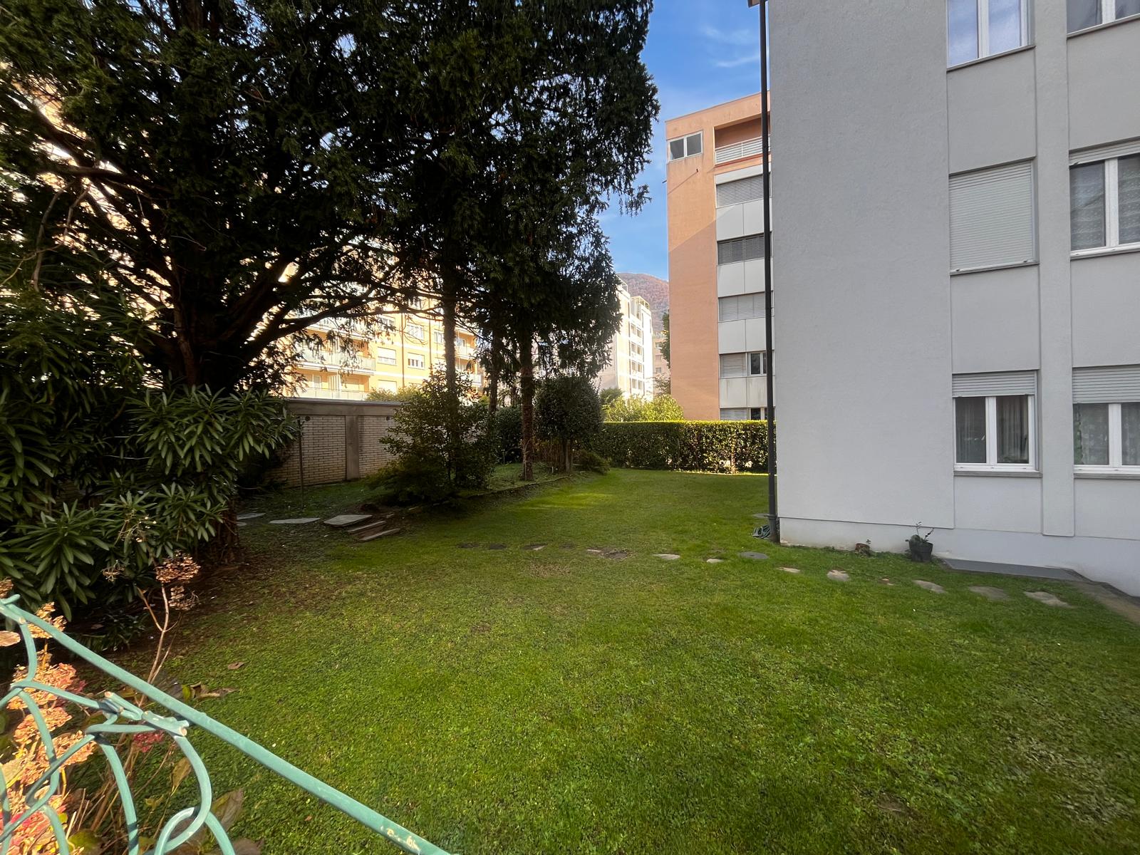Rear garden of Via del Tiglio 17 with tall trees and lawn